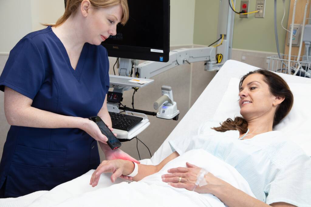 Healthcare employee using a Spectralink mobile device to scan patient wristband