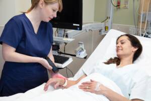 Healthcare employee using a Spectralink mobile device to scan patient wristband