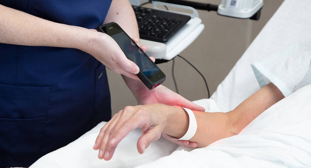 Healthcare worker using Spectralink device to scan patient wrist band