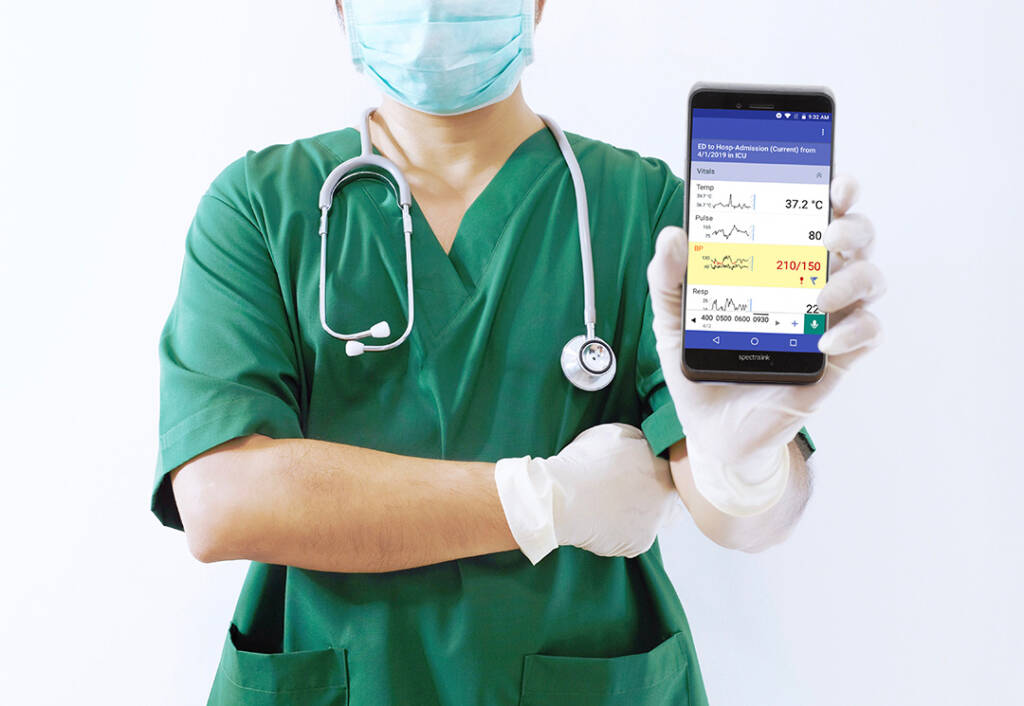 Healthcare worker in green uniform with Spectralink all-in-one mobile device