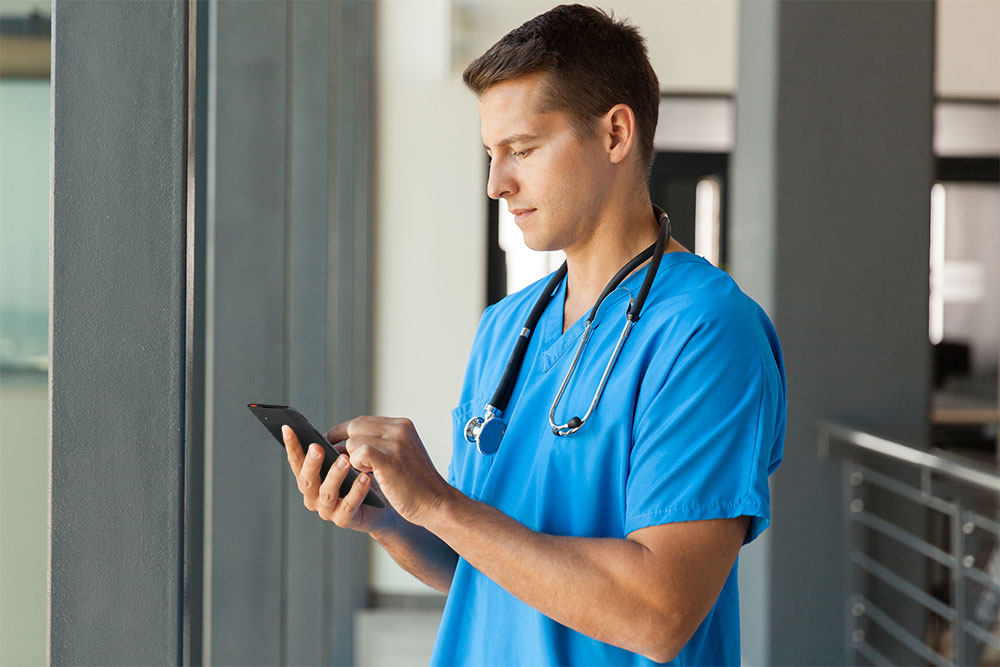 Healthcare worker looking at Spectralink mobile device