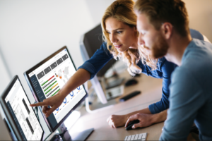 Man and woman looking at display on computer monitors