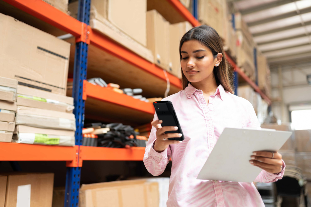 Industrial employee with clipboard uses Spectralink mobile device